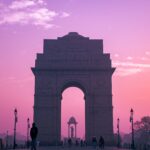 Home Stunning silhouette of India Gate during a pink sunrise in New Delhi, India.