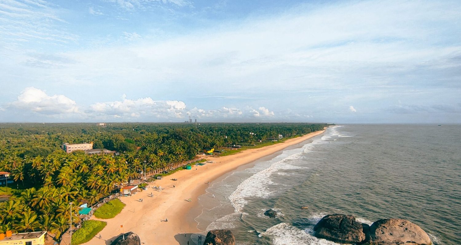 Stunning aerial shot of a tropical beach with golden sand and lush greenery, perfect for travel enthusiasts.